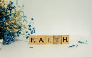 Letter tiles spell out the word faith in capital letters