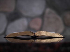 An image the Bible open in front of a rock wall