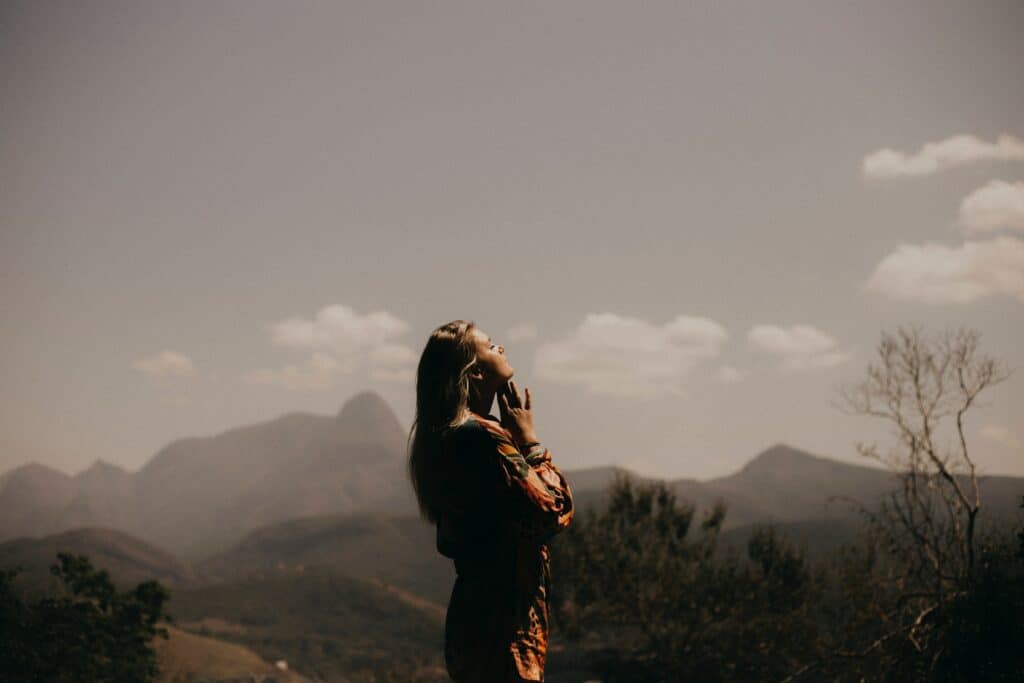 A woman stands looking toward the sky