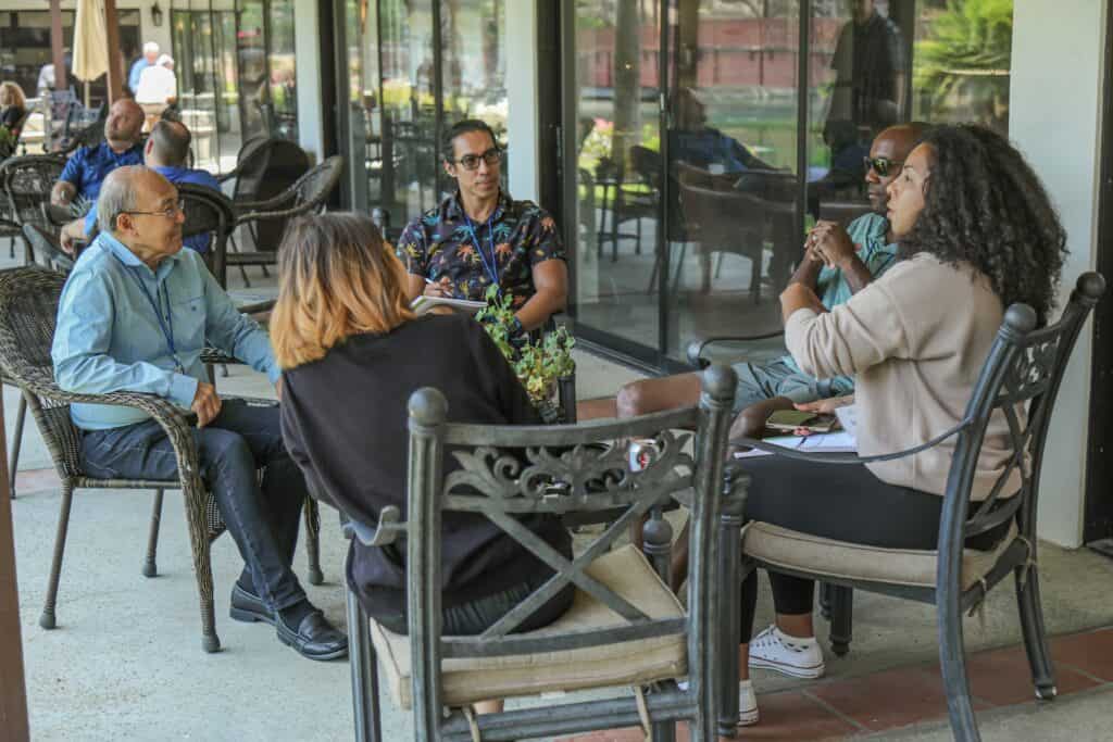 A group of people sit around a table talking.