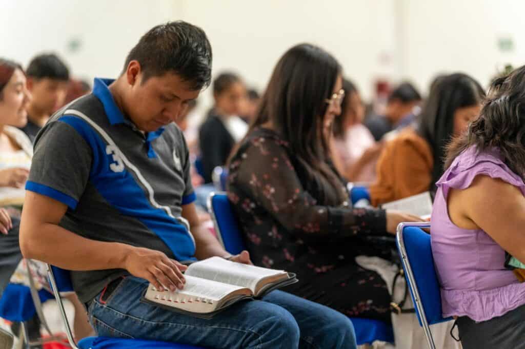 A man sits with the Bible open on his lap